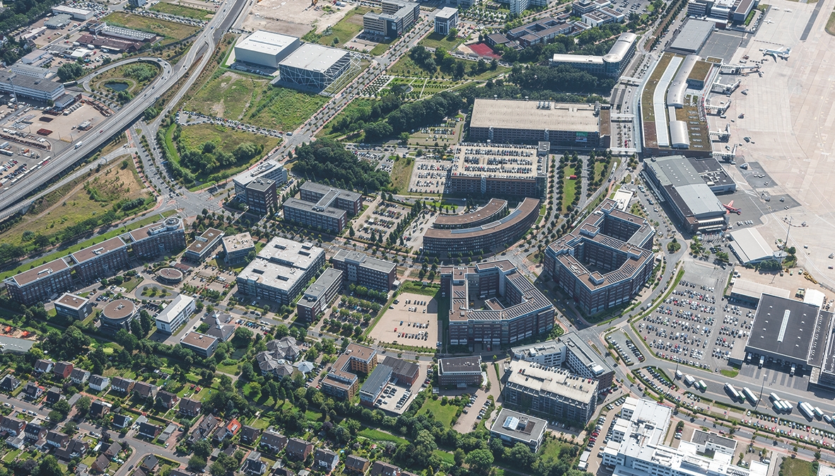 a photograph of a large building with a lot of buildings and trees